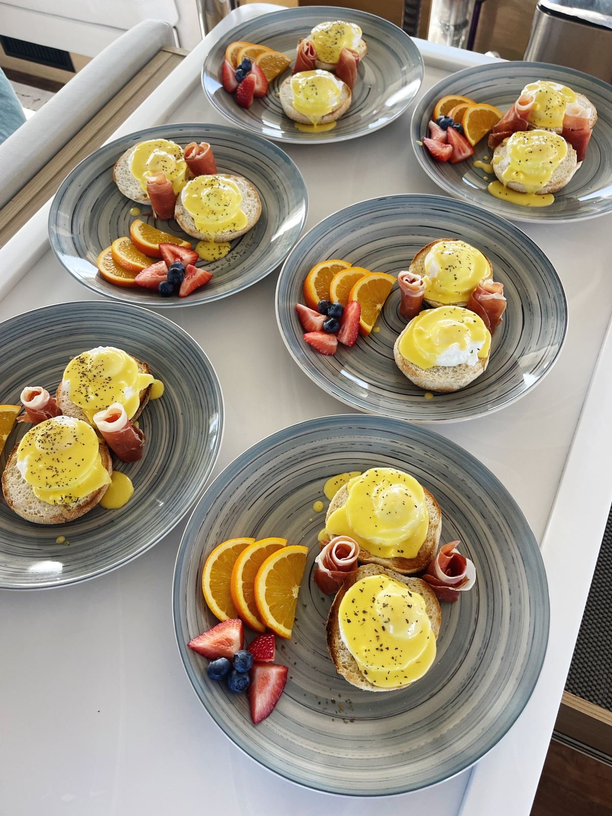 Breakfast plates being prepared on a galley counter